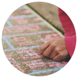 Child drawing with chalk on the ground