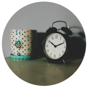 Vintage alarm clock next to a colorful candle holder