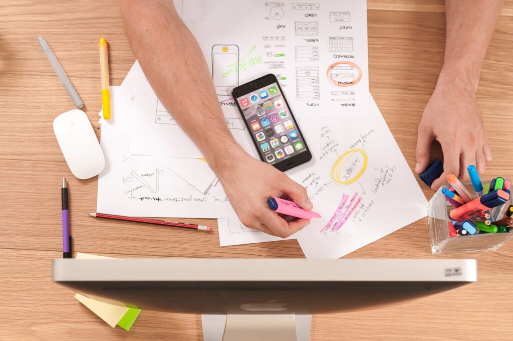 Desk with notes and smartphone showing planning process to hire writers