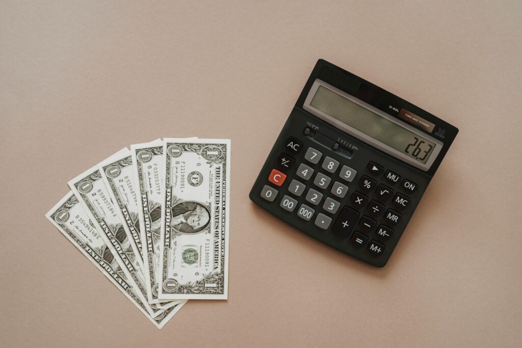 Calculator and dollar bills representing how much does it cost to hire a writer for content or SEO services