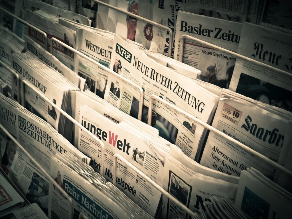 Stack of newspapers representing press release writing services and media distribution